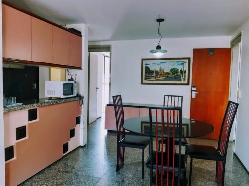 una cucina e una sala da pranzo con tavolo e sedie di Hotel Flat Atlântico, Apartamento Com 02 Quartos a Fortaleza