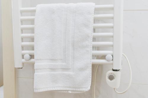 a white towel hanging on a towel rack in a bathroom at Cosy and Modern Flat in Porto in Porto