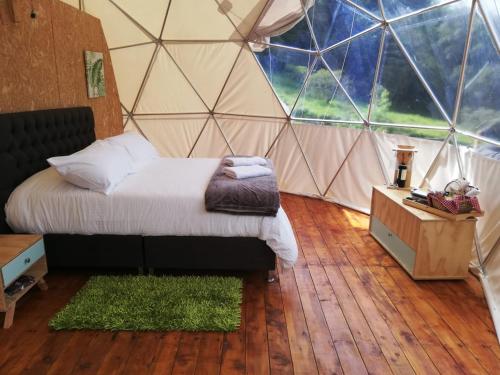 a bedroom with a bed in a dome tent at Glamping Aquamonti in Supatá