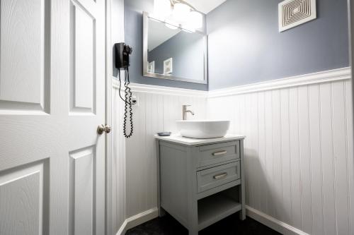ein Bad mit einem Waschbecken und einem Spiegel in der Unterkunft Mt. Madison Inn & Suites in Gorham