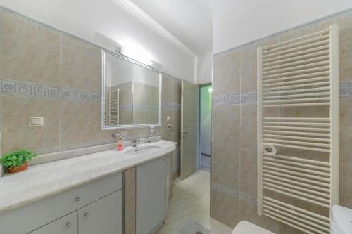a bathroom with a sink and a shower and a mirror at 3BD Apartment in the Center in Patra