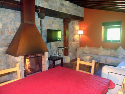 - un salon avec une cheminée et un canapé dans l'établissement Las Hayucas, à San Roque de Ríomiera
