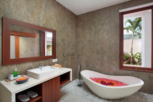 a bathroom with a bath tub and a sink at The Luxury Collection, Monaco Blu in Seminyak