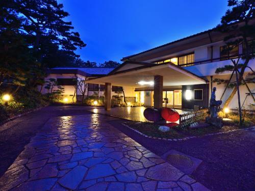 una casa con una entrada de piedra delante de ella por la noche en Hotel Hagoromo en Shizuoka