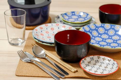 a table with plates and utensils on a table at Spacious & Modern Inn Megumi-an Nishijin in Kyoto