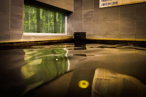 a pool of water in a building with a window at Super Hotel Kushiro-Ekimae in Kushiro