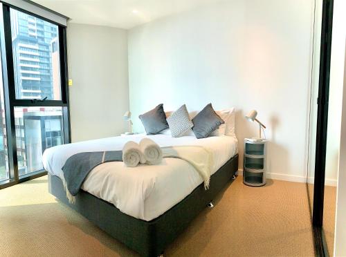 墨爾本的住宿－ReadySet Apartments at Lighthouse，一间卧室配有一张大床和两条毛巾