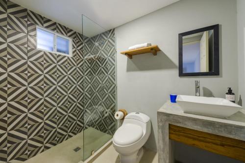 a bathroom with a toilet and a sink at Gaia Studios in Cancún
