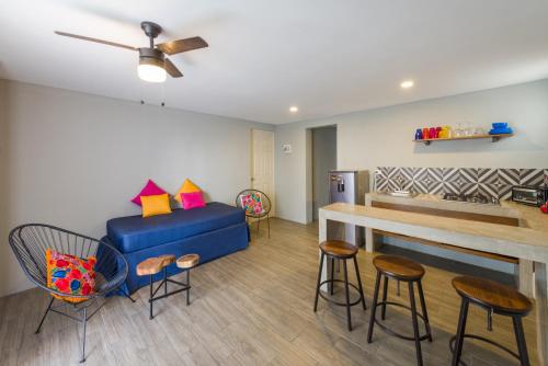 a living room with a blue couch and some chairs at Gaia Studios in Cancún