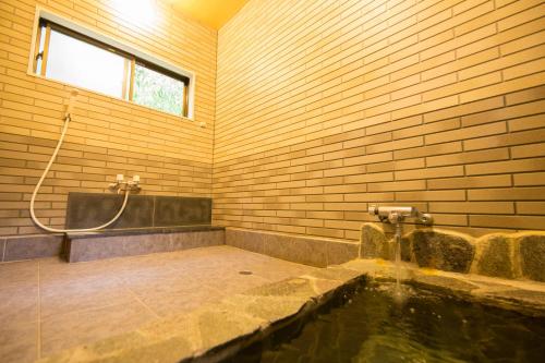 湯布院的住宿－Yufuin Tsukahara Kogen Sanso Donguri，带浴缸和盥洗盆的浴室