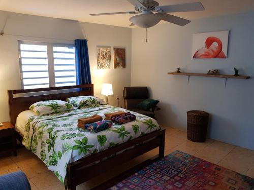 Un dormitorio con una cama y un ventilador de techo. en Charming home one block from the sea, en Willemstad