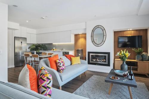 a living room with a couch and a fireplace at Residence du Parc Apartments By Staysouth in Queenstown