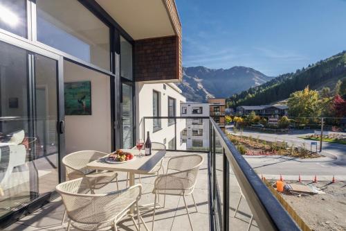 a balcony with a table and chairs and a view at Residence du Parc Apartments By Staysouth in Queenstown