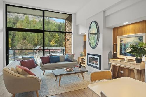 a living room with a couch and a fireplace at Residence du Parc Apartments By Staysouth in Queenstown