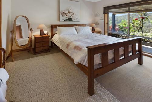 a bedroom with a large bed and a large window at Mt Taylor Country Retreat in Mount Taylor