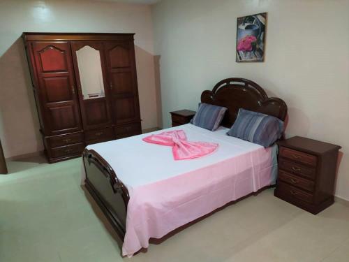 ein Schlafzimmer mit einem großen Bett mit einer rosa Schleife darauf in der Unterkunft Casa Cabral : Big Apartment next to the beach in Tarrafal