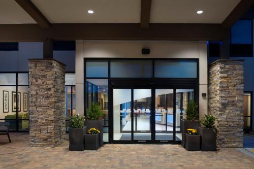a building with a glass door with potted plants at Holiday Inn Express & Suites Kingsland I-95-Naval Base Area by IHG in Kingsland