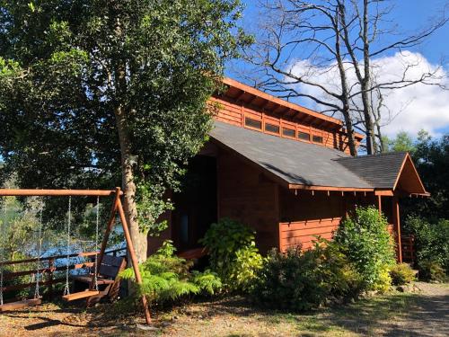 a log cabin with a gambrel roof at Cabañas Borgolafquen in Panguipulli