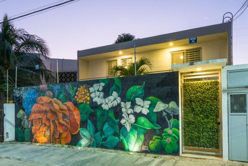 a mural on a wall in front of a building at Gaia Studios in Cancún
