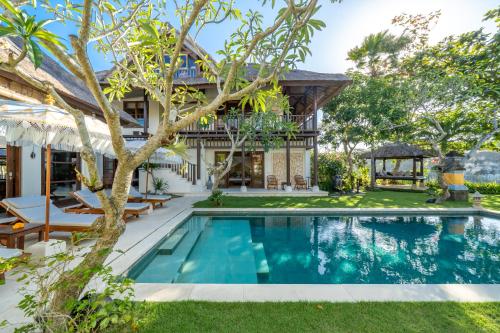 an image of a swimming pool in front of a house at Jimbaran Beach Villas by Nakula in Jimbaran