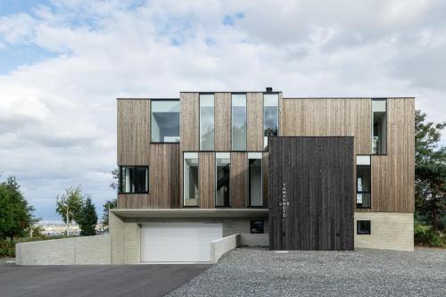 a house with a wooden facade with a door at Yama no Oto in Furano