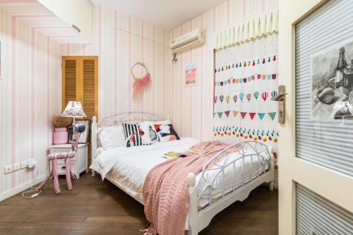 a pink and white bedroom with a bed and a window at King'sLandind BnB in Chongqing