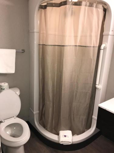 a bathroom with a shower curtain and a toilet at Motel 6-Fort Wayne, IN in Fort Wayne