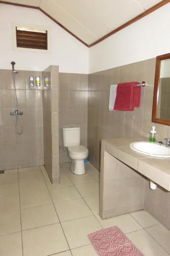 a bathroom with a toilet and a shower and a sink at Golo Hilltop Hotel in Labuan Bajo