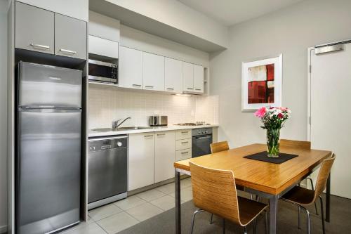 a kitchen with a wooden table with a vase of flowers at Gladstone Downtown Central Apartment Hotel Official in Gladstone