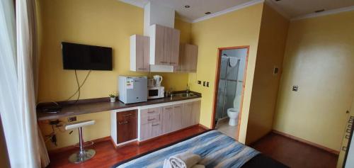 a small kitchen with a sink and a microwave at Apart Hotel Uman in Concepción