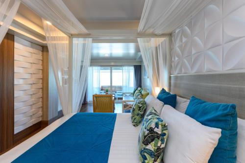 a bedroom with a large blue bed with blue pillows at Maldives Beach Resort in Chao Lao Beach