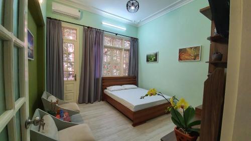 een kleine slaapkamer met een bed en een raam bij De Studio HomeStay in Hanoi