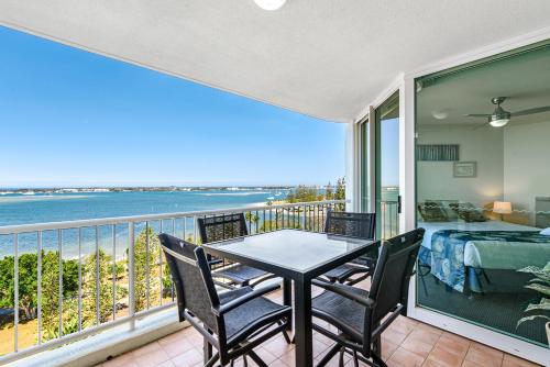 a dining room table with a balcony overlooking the ocean at Crystal Bay On The Broadwater in Gold Coast