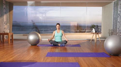 a woman sitting in a yoga pose in a room at Departamento de playa - Condominio OCEAN REEF - SAN BARTOLO in San Bartolo