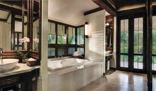 La salle de bains est pourvue d'une baignoire, d'un lavabo et de fenêtres. dans l'établissement Rayavadee- SHA Extra Plus, à Railay Beach