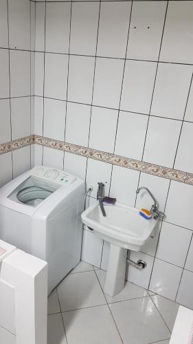 Baño blanco con aseo y lavamanos en Apto 2 quartos em Torres-RS, en Torres