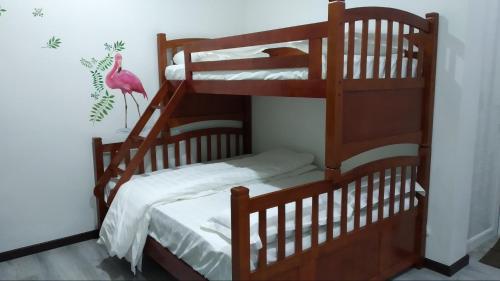 Penampangにある爱上海蓝蓝屋民宿 Blue Ocean Stationのピンクの鳥が1匹いる部屋の二段ベッド2組