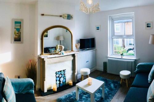 a living room with a fireplace and a mirror at Seascape Cottage, Ventnor in Ventnor