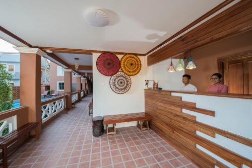 a bar in a restaurant with two people standing behind it at Traveller Lodge Ngapali by River Top in Ngapali