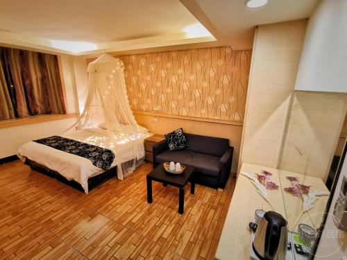 a bedroom with a bed and a couch and a table at Yilan Golf B&B in Wujie