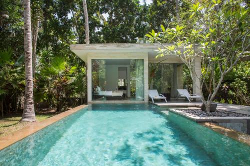 a swimming pool in a villa with a house at Kelapa Retreat & Spa in Pulukan