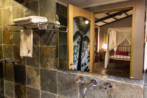 a bathroom with a sink and a mirror at Hotel Bougainviller in Kampala