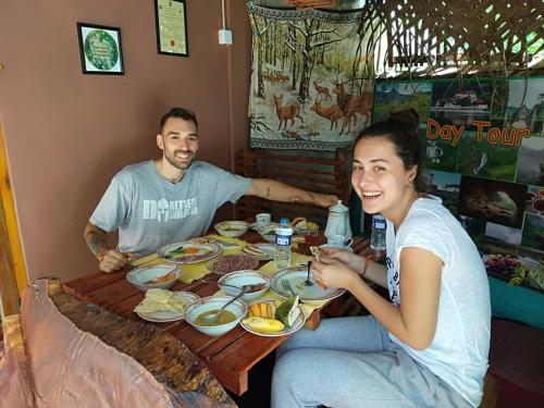 a man and a woman sitting at a table with food at Homeaway Homestay Hatton in Hatton