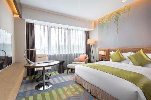 una camera d'albergo con letto, scrivania e sedia di Holiday Inn Shaoguan Downtown, an IHG Hotel a Shaoguan