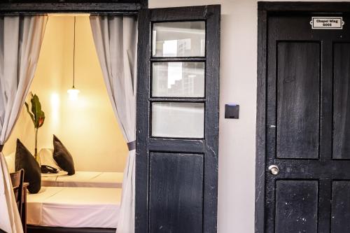 a room with a black door and a bed at The Marian Boutique Lodging House in Kuching