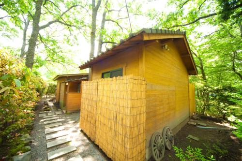 a small wooden house in the middle of a forest at Yufuin Tsukahara Kogen Sanso Donguri in Yufuin