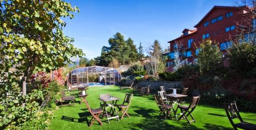 a garden with tables and chairs on the grass at Luces del Poniente in Cercedilla