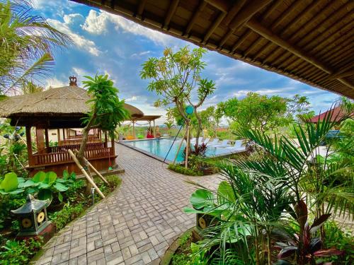 a resort with a swimming pool and a pavilion at Odiyana Bali Retreat in Banyuwedang