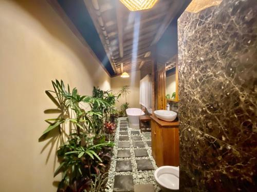 a bathroom with two sinks and plants in it at Odiyana Bali Retreat in Banyuwedang