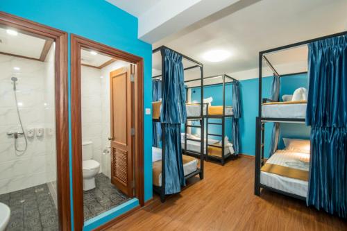 a room with four bunk beds and a bathroom at Traveller Lodge Ngapali by River Top in Ngapali